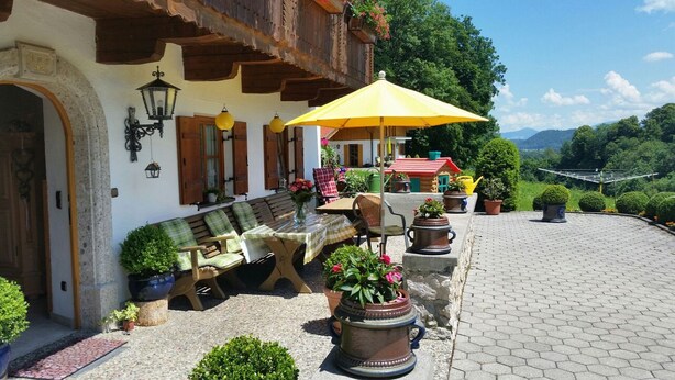 A traditional chalet with a patio, outdoor seating, and potted plants. - Ferienwohnung Almstüberl mit Südbalkon, 1-3 Personen, 50 qm (Bad Reichenhall)