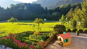 A rural landscape with a small wooden cabin, a fenced garden, and a field. - Ferienwohnung Almstüberl mit Südbalkon, 1-3 Personen, 50 qm (Bad Reichenhall)