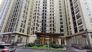 A high-rise building with a modern design, featuring multiple balconies and a covered entrance area with plants. - ARSAKHA 003 Transpark cibubur By Karlina (Depok)