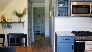 A modern kitchen with grey cabinets, a stainless steel stove, and a microwave.
