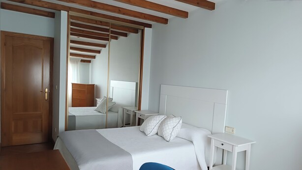 A bedroom with a bed, bedside tables, a desk, and a chair. - Apartamento Sleeps 6 with Garage (Cambados)