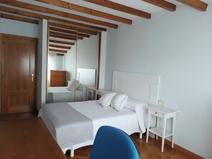 Ein Schlafzimmer mit einem Bett, Nachttischen, einem Schreibtisch und einem Stuhl.