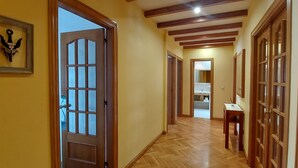 A hallway with wooden floors, a door with glass panels, and a framed object on the wall. - Apartamento Sleeps 6 with Garage (Cambados)