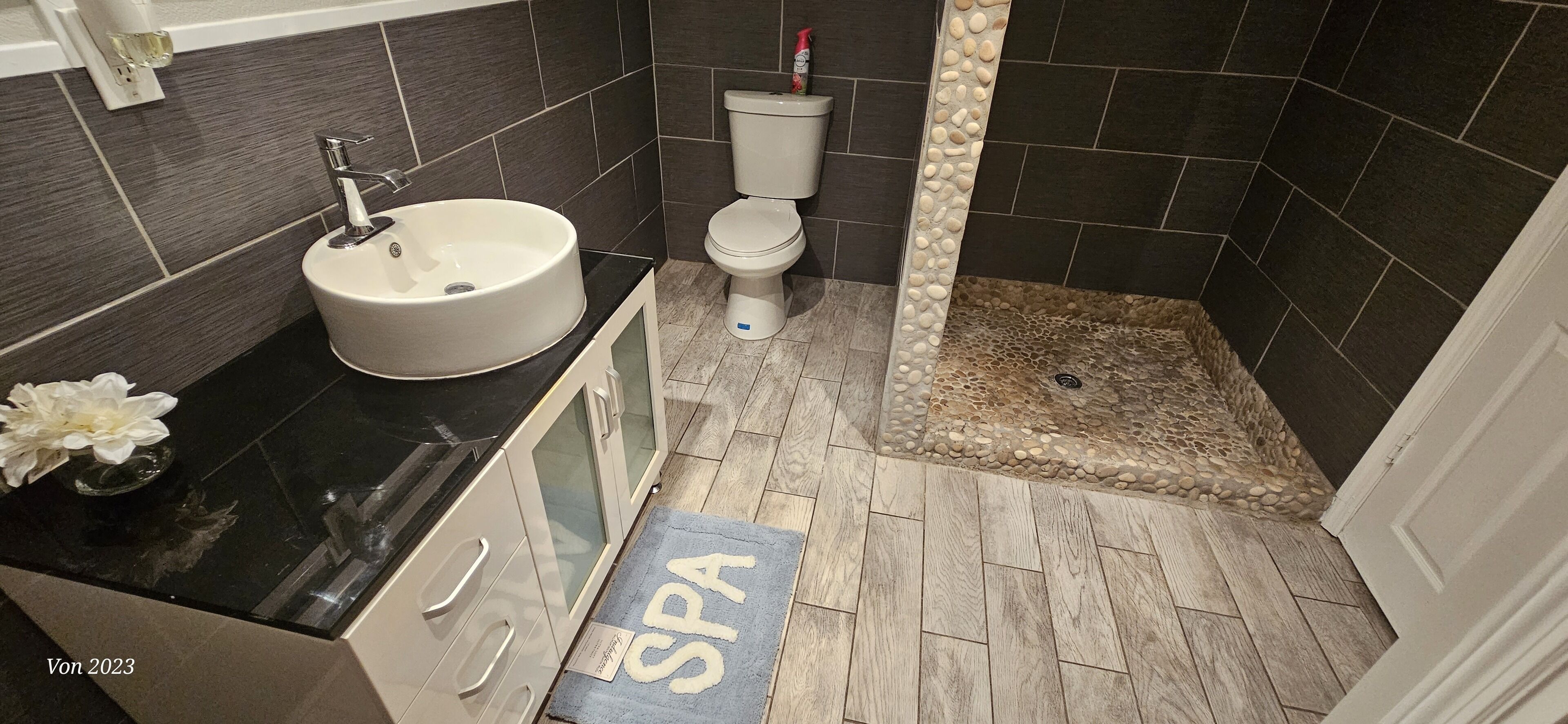 A modern bathroom with a sink, toilet, and shower area.