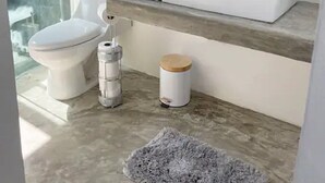 A modern bathroom with a toilet, a shower, and a sink area.