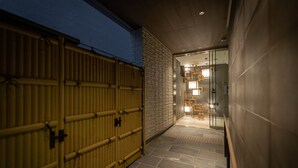 A corridor with a bamboo gate, stone flooring, and a modern interior with wooden furniture. - Hotel Liberte Kyoto Gojo (Kyoto)