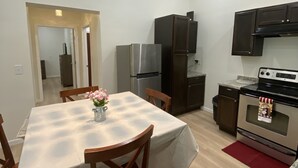 Una cocina moderna con comedor, electrodomésticos de acero inoxidable y encimera de mármol.