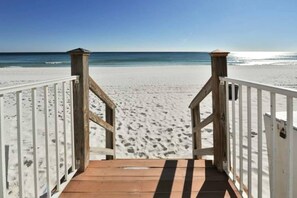 A wooden boardwalk leading to a sandy beach with a clear blue sky. - Destin Towers 1C (Destin)