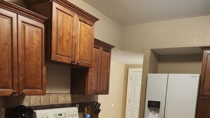 Eine Küche mit Holzschränken, einem weißen Herd und einem weißen Kühlschrank.