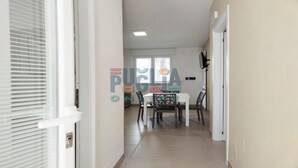 Un couloir menant à une salle à manger équipée d’une table et de chaises.