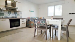 Une cuisine moderne équipée d’une cuisinière, d’un four et d’un coin repas avec une table et des chaises.