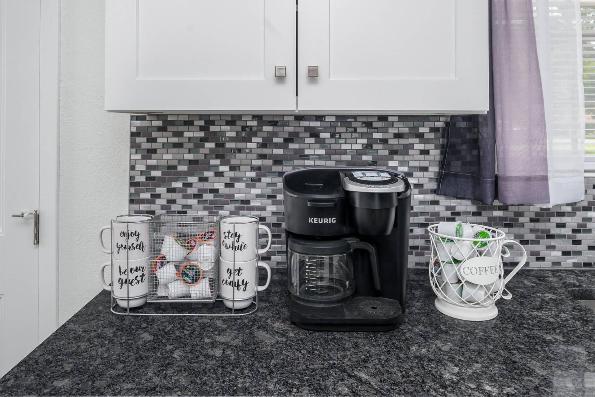 A kitchen with a coffee maker, a mug rack, and a coffee basket.