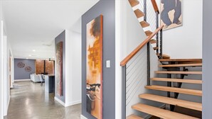 Un intérieur moderne avec un escalier en bois, un coin cuisine et un espace repas.