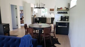 Et moderne køkken med spiseplads, der inkluderer et rundt bord, stole og en indbygget ovn.