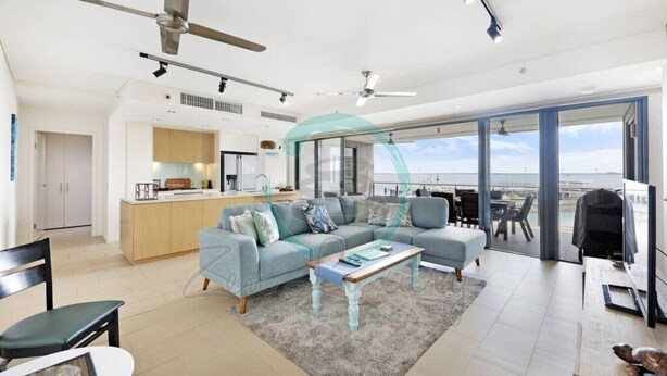 Ein modernes Wohnzimmer mit Sofa, Couchtisch und Blick auf die Stadt durch große Fenster.
