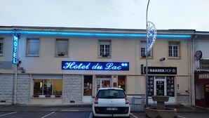 Ein Gebäude mit einem Neon-Schild, auf dem 'Hotel du Lac' steht.