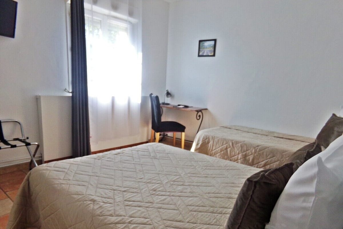 Une chambre avec deux lits, un bureau et une chaise.