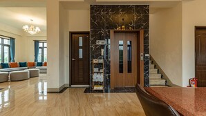Un salón amplio con un sofá grande, una mesa de comedor y una escalera que sube a un piso superior.