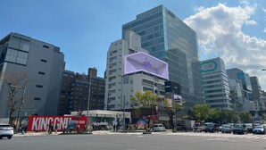 A cityscape with modern buildings, including a Balenciaga store and a Galaxy sign. - INN THE OMOTESANDO (Tokyo)