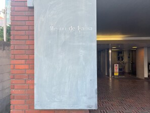 Un pasillo con un letrero que dice "Mezon de Lamia" y suelo de baldosas.