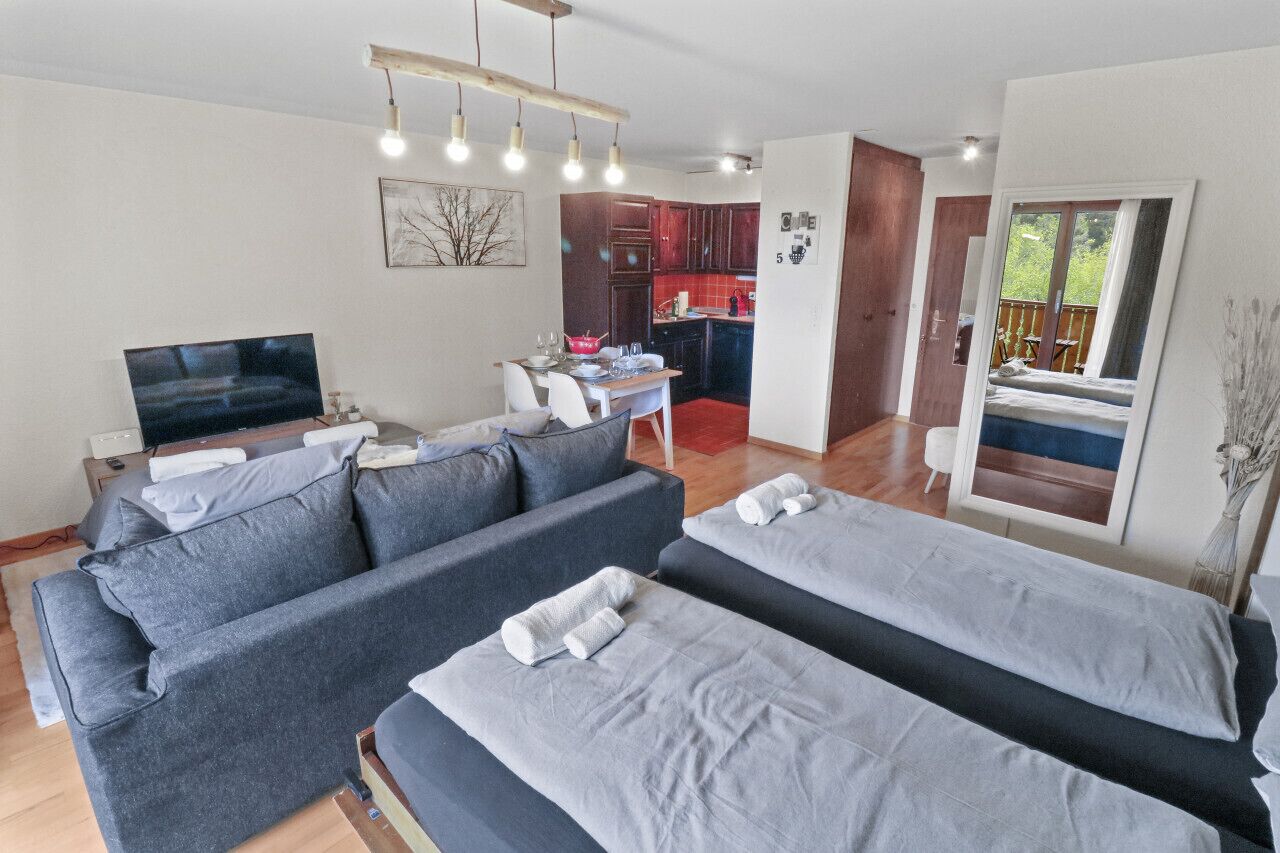 Una sala de estar moderna con un conjunto de sofá, televisor y comedor.