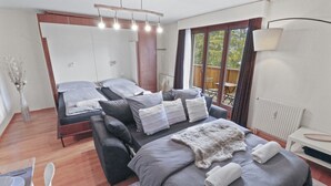 Une chambre moderne dotée d’un grand lit, d’un canapé-lit et d’un espace nuit séparé.