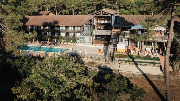 Un resort con piscina, mobiliario exterior y un edificio con varios balcones.