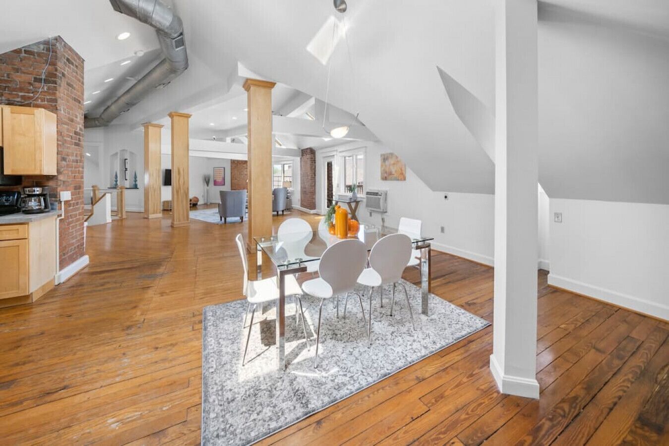 Un vaste appartement de style « loft » avec de hauts plafonds, des conduits apparents et un mélange de revêtements de sol en bois massif et de moquette.
