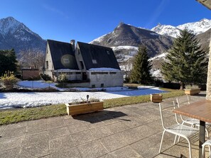 Situated in a mountainous region, this chalet-style building offers a cozy patio with seating and a garden area.