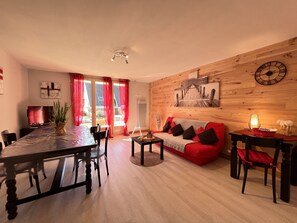 Relax in this stylish living room with a sofa, dining table, and flat-screen TV.