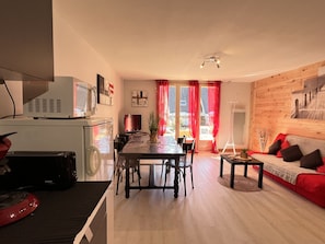 Un espacio habitable moderno con comedor, sofá y televisor.