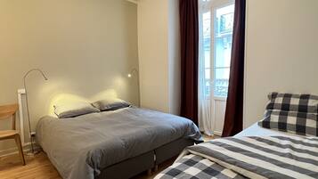 2 dormitorios y tabla de planchar con plancha