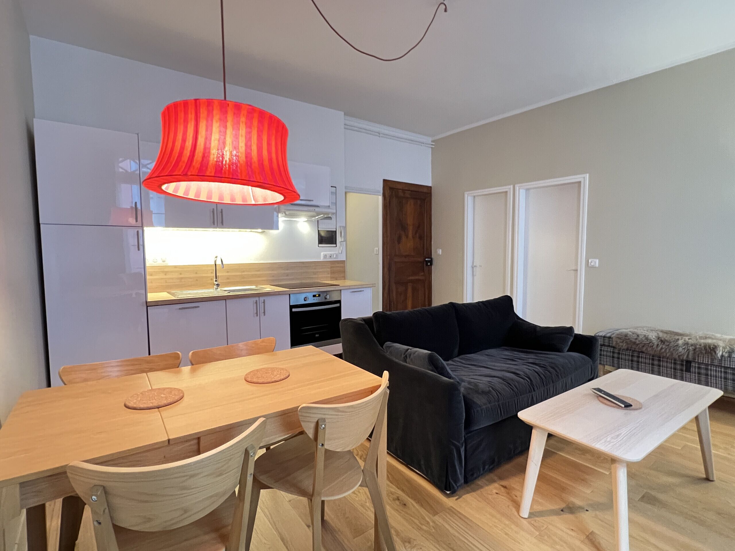 A compact living space with a dining area, a sofa, and a small table.