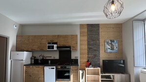 Une cuisine moderne dotée d’armoires en bois, d’un four à micro-ondes, d’un lave-vaisselle et d’un four encastré.