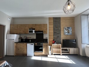 Una cocina moderna con armarios de madera, microondas, lavavajillas y horno empotrado.