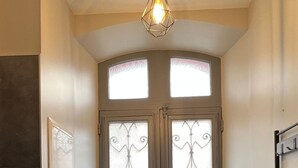 A double door with a key lock and a handle, a light fixture above, and a bench to the right.