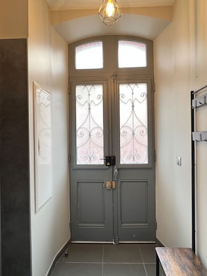 Puertas dobles con paneles de vidrio esmerilado y un diseño decorativo de metal.