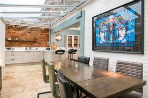Enjoy meals in the dining area with a wooden table and leather chairs.