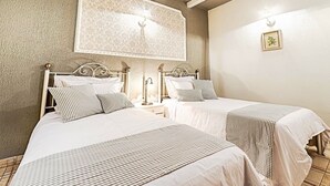 Une chambre d’hôtel avec deux lits, un grand élément décoratif mural et un petit tableau encadré accroché au mur.