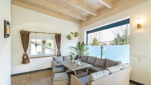 A cozy living room with a sectional sofa, a small table, and wicker furniture.