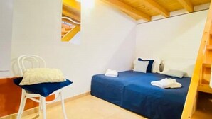 Una habitació petita i acollidora amb un llit, una cadira i un sostre de fusta.