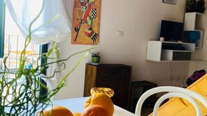 Una habitació amb una taula blanca, un cistell d'albercocs i un quadre al mur.