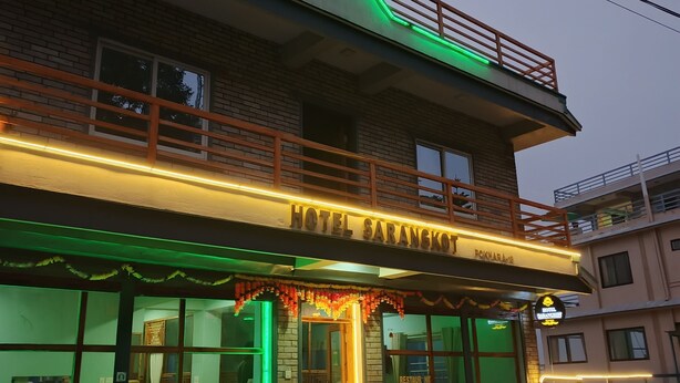 Ein Hotel mit Balkon, einem Schild mit der Aufschrift „HOTEL SARANGKO“ und einem Restaurantschild.
