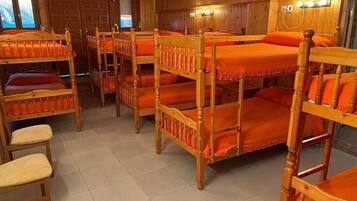 A room with bunk beds and wooden walls.