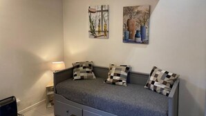 A bedroom with a bed, a nightstand, and two wall-mounted paintings. - La Campagne Proche de Paris - Chez Lulu (Montreuil)