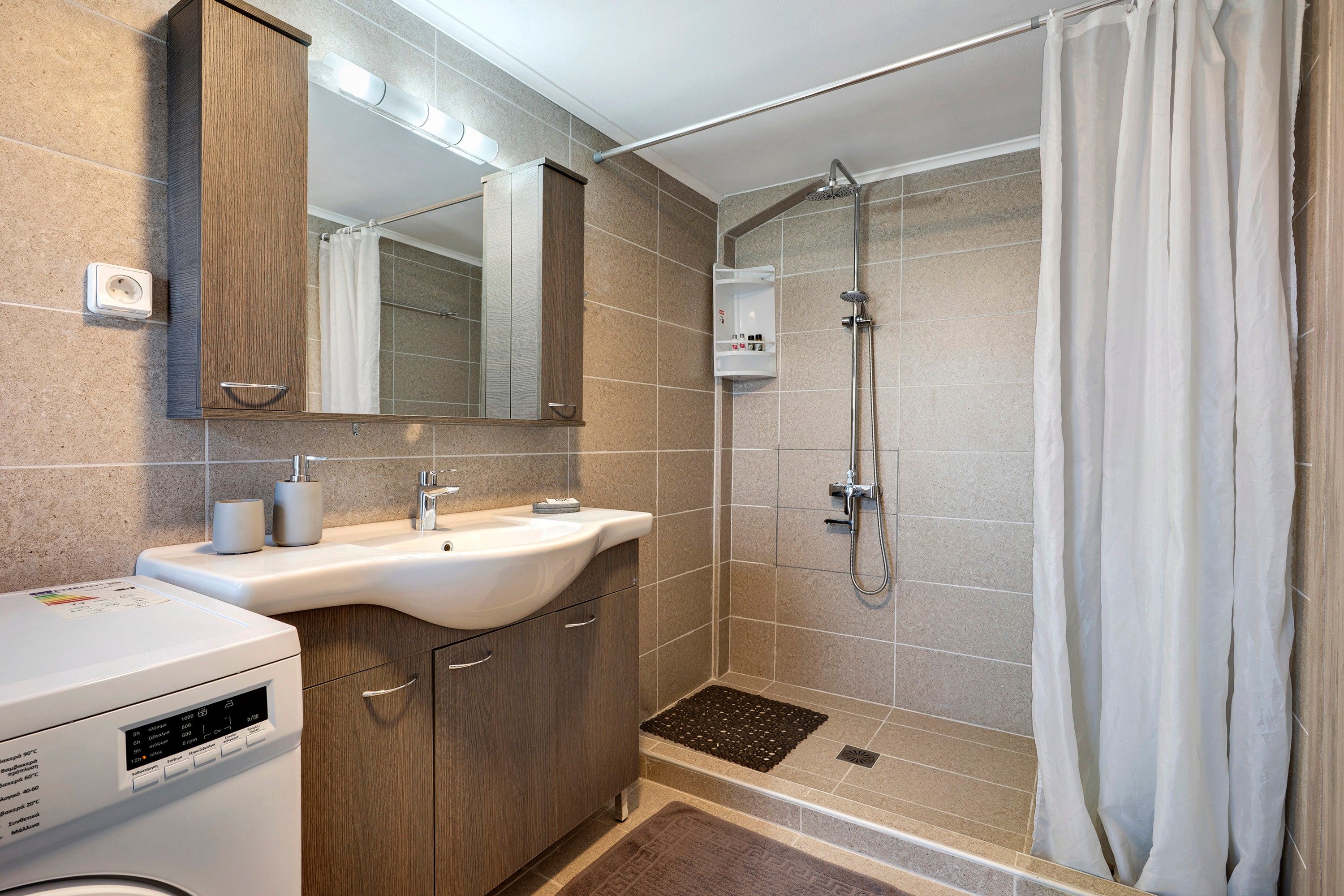 A modern bathroom with a shower, a sink, and a mirror.