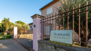 Propiedad amurallada con un letrero que indica 'L'Aramont' e información de contacto.