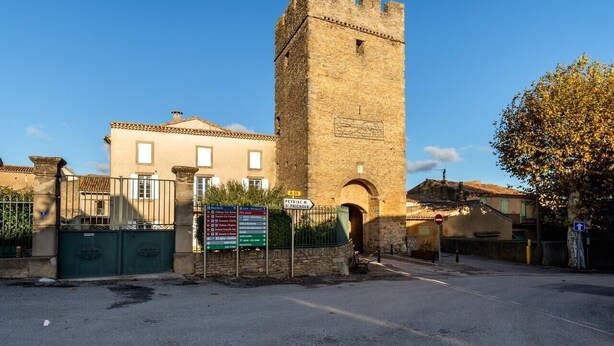 Una torre de piedra histórica con una puerta y una placa.