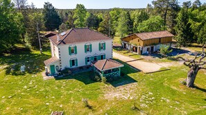 A large two-story house with a tiled roof, a covered patio, and a well-maintained lawn. - Domaine Les Maisons Des Houssats with Shared Pool (TRENSACQ)