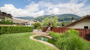 A residential area with a pond, greenery, and a mountain backdrop. - Apartment 'Mignon B' with Mountain View, Shared Garden and Wi-Fi (Riffian)
